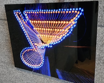 May include: A close-up of a swirling, abstract design created with blue and orange lights. The lights are arranged in a circular pattern, creating a sense of movement and energy.