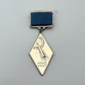 Una insignia conmemorativa de la URSS dedicada a la misión de la estación interplanetaria automática Luna-2.