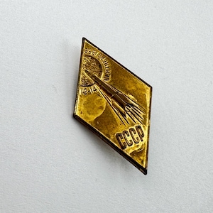 Puede incluir: Una taza de cerámica blanca con un asa negra y el texto "But First, Coffee" en negrita negra. La taza se encuentra sobre un fondo borroso, resaltando su diseño simple.