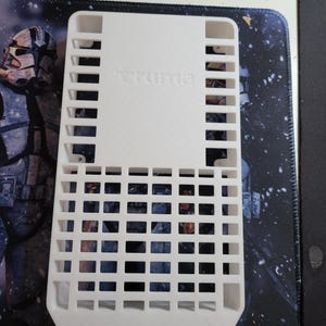 Peut inclure: Organiseur de rangement en plastique blanc imprimé en 3D avec un motif en grille et le mot "SUMMIT" imprimé sur le devant.