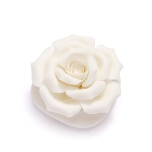 May include: A cream-colored rose, fully bloomed, against a white background. The rose's petals are tightly layered in the center, gradually opening outwards. The overall shape is round and symmetrical, suggesting a decorative or ornamental item.