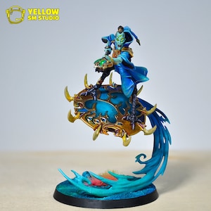 May include: A blue and gold miniature figure of a sorcerer riding a swirling blue disc. The sorcerer is wearing a blue robe and a pointed hat. The disc has a gold rim and intricate details.