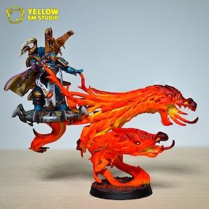 Puede incluir: Figura de fantasía en miniatura de un guerrero con armadura azul, de pie sobre una plataforma sobre dos criaturas parecidas a dragones de fuego. La figura tiene detalles dorados y una capa púrpura. La base es negra.
