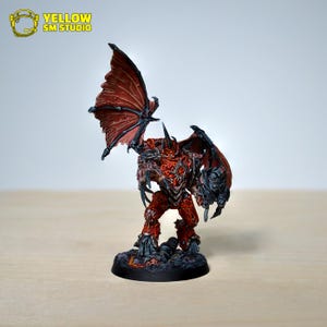 Könnte beinhalten: Detaillierte Miniaturfigur einer dämonischen Kreatur mit roter und schwarzer Rüstung, großen Flügeln und Hörnern. Die Figur steht auf einem strukturierten Sockel. Der Text "YELLOW SM STUDIO" befindet sich in der oberen linken Ecke.