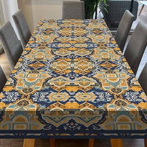 May include: A blue and gold patterned tablecloth with a geometric design. The tablecloth is laid out on a wooden table with chairs around it.