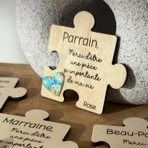 Peut inclure: Pièces de puzzle en bois avec texte gravé et cœurs décoratifs. Le texte comprend des phrases comme « Merci d'être une pièce si importante de ma vie ». Une pièce a un cœur bleu et argenté, une autre un cœur rose et une autre un cœur blanc.