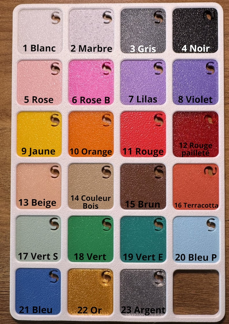 May include: A color chart with 23 different paint colors, labeled with numbers and French names. The colors include white, black, gray, pink, purple, yellow, orange, red, beige, brown, green, blue, gold, and silver.