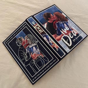 Può includere: Due libri intitolati The Deal di Elle Kennedy. Una copertina presenta un'illustrazione a colori di una coppia che si bacia, con la persona a destra che indossa una maglia da hockey blu. L'altra copertina mostra una versione a linee bianche.