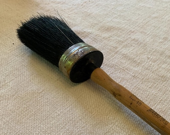 May include: A paint brush with a wooden handle and black bristles. The handle is labelled "Blu-48".