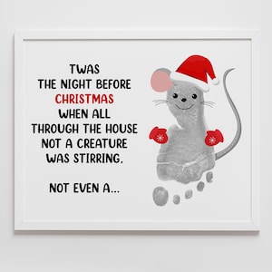 Puede incluir: Impresión enmarcada con el texto "Twas the night before Christmas" y una huella gris en forma de ratón con gorro y mitones de Papá Noel. Fondo blanco.