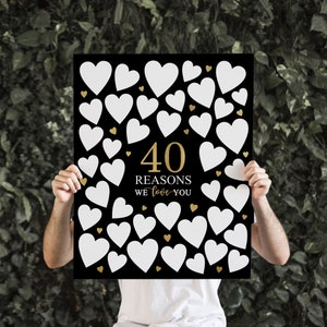 May include: Black poster with 40 white hearts and gold hearts. The poster says "40 Reasons We Love You" in gold lettering.