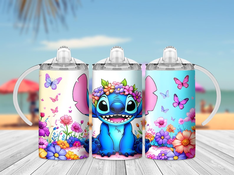 May include: Three stainless steel tumblers with lids and handles. Each tumbler features a different design of a blue cartoon character with a flower crown and pink ears, surrounded by colorful flowers and butterflies. The designs are on a white, light blue, and pink background.
