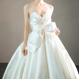 Robe de mariée moderne sans bretelles en soie Mikado ivoire robe de mariée trapèze complète plis perles nœud amovible robe de mariée personnalisée train chapelle