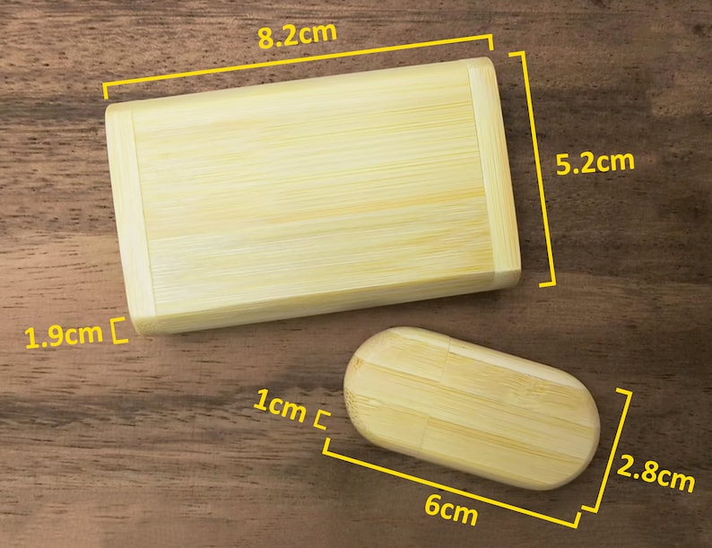 Op de afbeelding: Twee houten dozen gemaakt van bamboe. De grotere doos is 8,2 cm lang, 5,2 cm breed en 1,9 cm hoog. De kleinere doos is 6 cm lang, 2,8 cm breed en 1 cm hoog.
