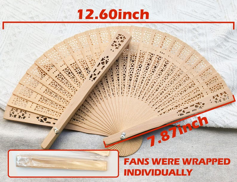 May include: Two open wooden fans with intricate cut-out designs. Each fan measures 12.60 inches wide and 7.87 inches high. A smaller, wrapped fan is visible. The fans are light brown and appear to be made of wood.