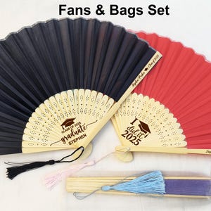 May include: Two graduation fans with personalized messages. One fan is black with the text "Class of 2023 graduate Stephen" and the other is red with the text "I did it 2023".