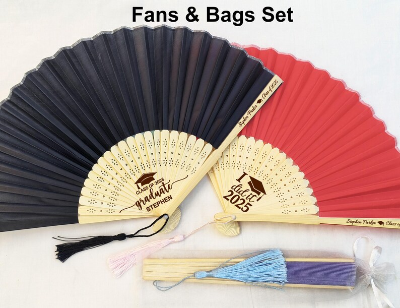 May include: Two graduation fans with personalized messages. One fan is black with the text "Class of 2023 graduate Stephen" and the other is red with the text "I did it 2023".