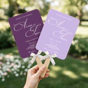 Puede incluir: Dos abanicos rectangulares para programas de boda con esquinas redondeadas, uno en morado oscuro y otro en lavanda claro. Ambos presentan texto blanco que dice "Welcome to the wedding of Alyson and Timothy, August 15, 2026" con lazos blancos.