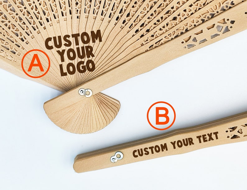 May include: Two wooden folding fans with custom text. The top fan has a brown handle and a white, intricate design. The text on the fan reads "CUSTOM YOUR LOGO". The bottom fan has a brown handle and a simple design. The text on the fan reads "CUSTOM YOUR TEXT".
