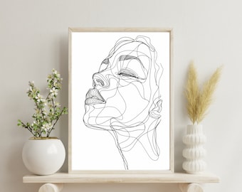 Könnte beinhalten: Ein gerahmter Kunstdruck mit einer schwarzen, durchgehenden Linienzeichnung eines Gesichts im Profil auf weißem Hintergrund. Das Kunstwerk zeigt einen stilisierten menschlichen Kopf mit geschlossenen Augen und definierten Lippen in einem hellen Holzrahmen.