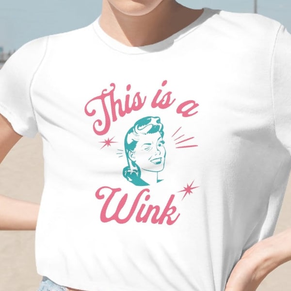 This is a Wink Women's Flowy Cropped T-Shirt, Pink Shirt, Baby Tee, Popular Right Now, Classy Shirt, Pinup, Smiley Face Tee, Retro Crop Top