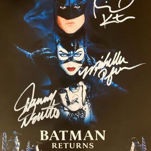 Może przedstawiać: Plakat filmowy Batman Returns z Batmanem, Catwoman i Pingwinem. Plakat ma tytuł filmu w białym tekście na dole, z podpisami aktorów nad ich postaciami. Tło jest ciemnoniebieskie.