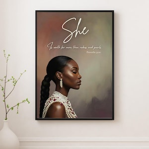 Op de afbeelding: Een ingelijste kunstdruk met een zijaanzicht van een vrouw met een donkere huid, die parelsieraden en een gevlochten kapsel draagt. Het kunstwerk bevat het woord "She" in cursief en een citaat uit Spreuken 3:10.