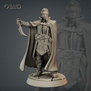 May include: A detailed figurine of a man in a cloak, holding a curved blade. The figure is wearing a tunic, boots, and a belt with a sword. The word "GALAAD" is at the top left corner. The figurine is on a circular base.