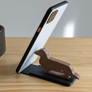 Soporte para teléfono con forma de perro salchicha - Varios colores disponibles