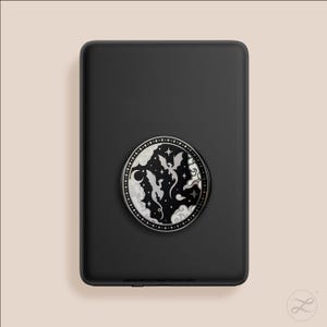 May include: Black phone grip with a circular design featuring a silver dragon and cloud illustration. The design is set against a white background with a starry border. The phone grip is attached to a black phone case.