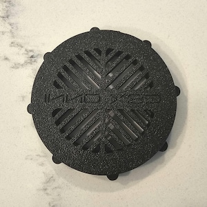 May include: Black plastic drain cover with a circular design and the text "Halo Design" in the centre.