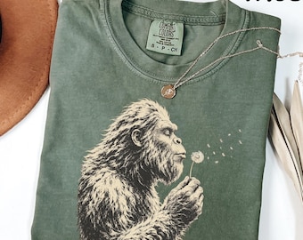 Comfort Colors® Bigfoot Blowing Dandelion Shirt, Peaceful Sasquatch Tee, Funny Bigfoot Shirt, Woodland Cryptid Shirt, Nature Lover Gift