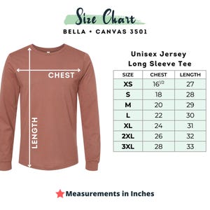 May include: A terracotta-colored long-sleeve tee shirt with a size chart. The chart provides chest and length measurements in inches for sizes XS to 3XL. The text "Size Chart" and "Unisex Jersey Long Sleeve Tee" are also visible.