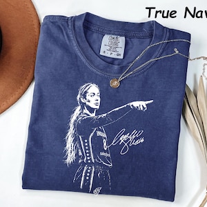 May include: A true navy blue short-sleeve t-shirt featuring a white graphic print of a basketball player pointing forward with a signature. The shirt has a crew neckline and a Comfort Colors brand label on the inside collar showing size small.