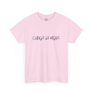 May include: Pink t-shirt with the text "CHINGA LA MIGR" printed in black.