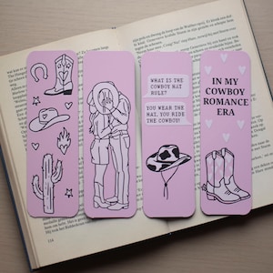 Puede incluir: Cuatro marcapáginas rosas con temática de vaqueros con ilustraciones en blanco y negro. Un marcapáginas presenta una pareja de vaqueros, otro tiene un sombrero de vaquero y los otros tienen botas de vaquero y otros iconos occidentales. El texto incluye "What is the cowboy hat rule?" y "In my cowboy romance era."