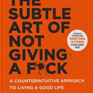 May include: A book with an orange cover, titled "The Subtle Art of Not Giving a F*ck" by Mark Manson. The cover features black text and a black ink splatter. It also states "#1 New York Times Bestseller". The book is a counterintuitive approach to life.