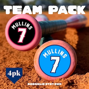 May include: Two pink baseball bats with circular end caps featuring the text MULLINS and the number 7. One cap has a black background, and the other has a blue background. The text TEAM PACK appears at the top, and 4pk is in a blue shield.