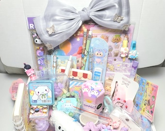 May include: A white gift box filled with assorted stationery and accessories, including a large silver hair bow with butterfly accents, Cinnamoroll themed items, stickers, pens, a small plush toy, a spiral notebook, and various colorful trinkets.