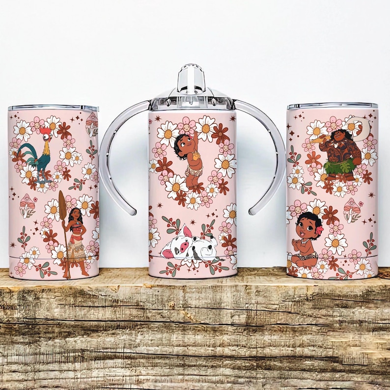 May include: Three pink tumblers with floral designs and cartoon characters. One tumbler has a lid, and the other has handles. The tumblers feature characters from a popular animated movie, surrounded by flowers and leaves.