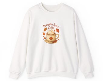 May include: White sweatshirt with a graphic of a pumpkin spice latte, whipped cream, a pumpkin, and a cinnamon stick. The words "Pumpkin Spice Latte" are above the coffee cup. Autumn-themed clothing.