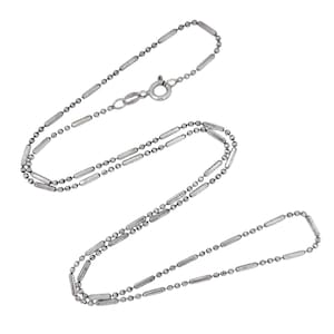 Peut inclure: Un collier argenté au design délicat. Le collier est composé d'une série de petites perles rondes entrecoupées de barres rectangulaires plus longues. Il possède une fermeture simple. Le bijou est présenté sur fond blanc.