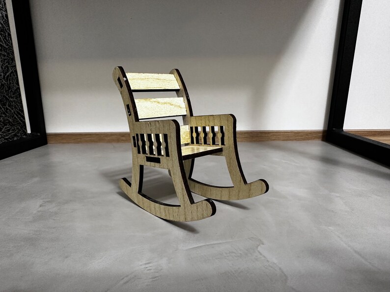 May include: A wooden rocking chair with a natural wood finish and black accents. The chair has a simple design with a curved back and a wide seat.