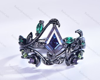 Può includere: Anello nero con una pietra preziosa blu scuro circondata da un motivo a vite con accenti verdi e viola.