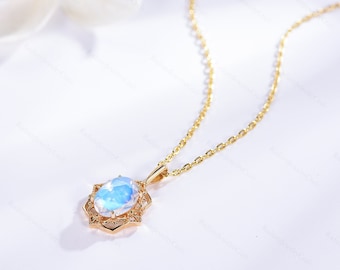 May include: A gold chain necklace with a delicate oval-shaped moonstone pendant set in a gold filigree design.
