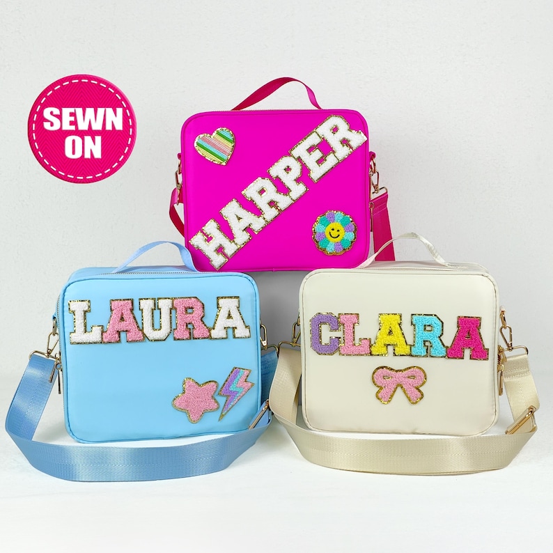 May include: Three personalized square crossbody bags in bright colors. One is hot pink with the name "HARPER", another is light blue with "LAURA", and the third is off-white with "CLARA". Each bag has a shoulder strap and decorative patches.