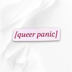 Puede incluir: Una pegatina rectangular con el texto "[queer panic]" en color burdeos. La pegatina está colocada sobre un fondo blanco texturizado con elementos de papel plegado.