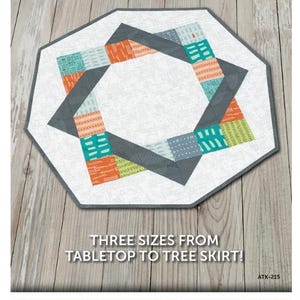 May include: A geometric quilt pattern with the text "GATHER ROUND" at the top. The quilt features a white center with a gray border and colorful patchwork squares in shades of orange, teal, and green. The text "THREE SIZES FROM TABLETOP TO TREE SKIRT!" is also visible.