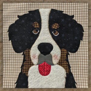 May include: A fabric square featuring a Bernese Mountain Dog design. The dog has black fur with star patterns, brown and white markings, and a red tongue. The background is a tan and white checkered pattern.