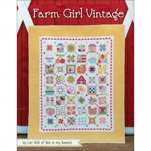 May include: A colorful quilt with a patchwork design featuring various farm-themed motifs like houses, cherries, and chickens. The quilt has a yellow border and the text "Farm Girl Vintage" at the top. The quilt is set against a red barn door background.